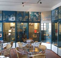 Aufnahme im Museumsfoyer mit Cafe-Tischen und Vitrinen im Hintergrund